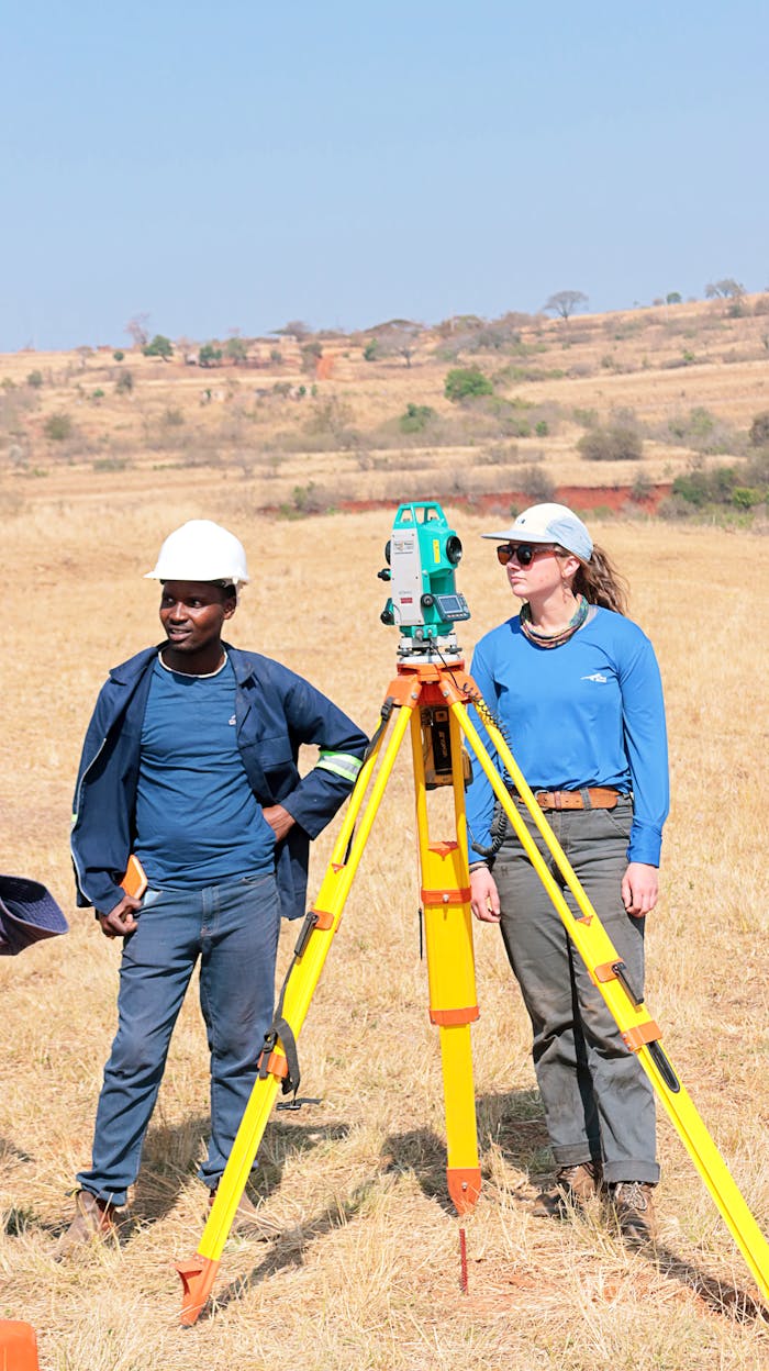 Engineers performing land survey in dry grasslands of Nhlangano, Eswatini.